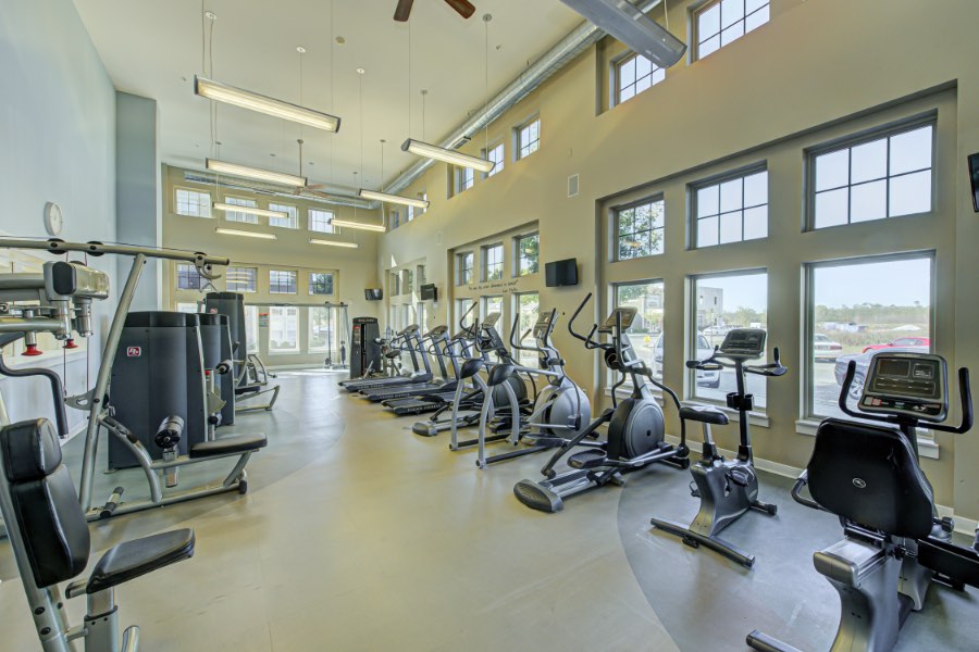 Apartment fitness center with aerobic and strength training equipment.
