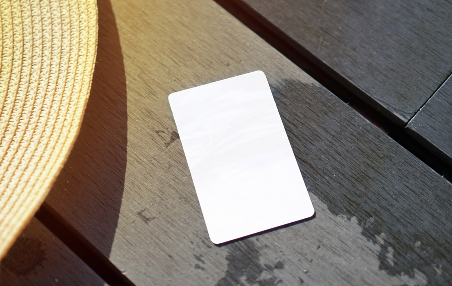 Don't forget your pool pass to to take a refreshing swim at StoneBridge Luxury Apartment Homes. Summer hat and key card on a deck floor.