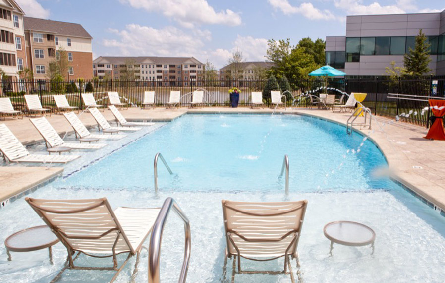 A beautiful blue pool enhances your apartment experience in Indianapolis. Lake side pool on a sunny day.
